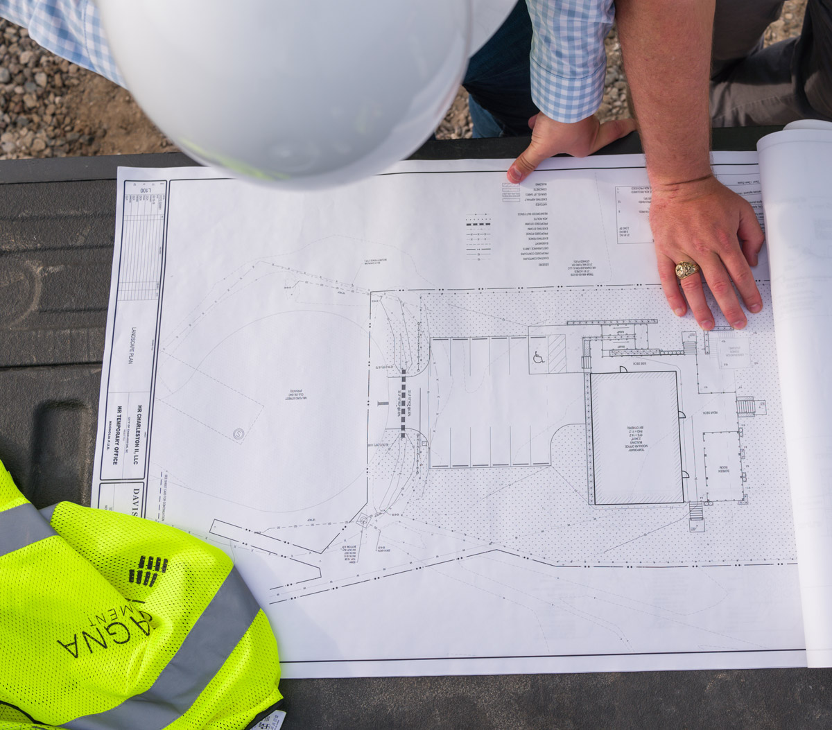 Man looking over blueprints for cost management and estimating of construction projrect